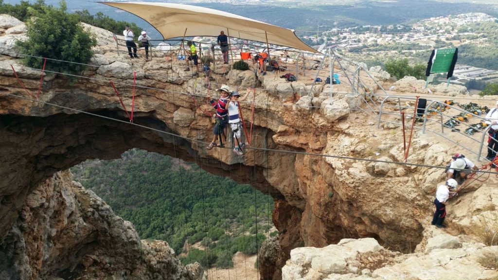 סנפלינג בצפון מערת קשת קבוצת מטיילים בפעילות סנפלינג עם אשדות
